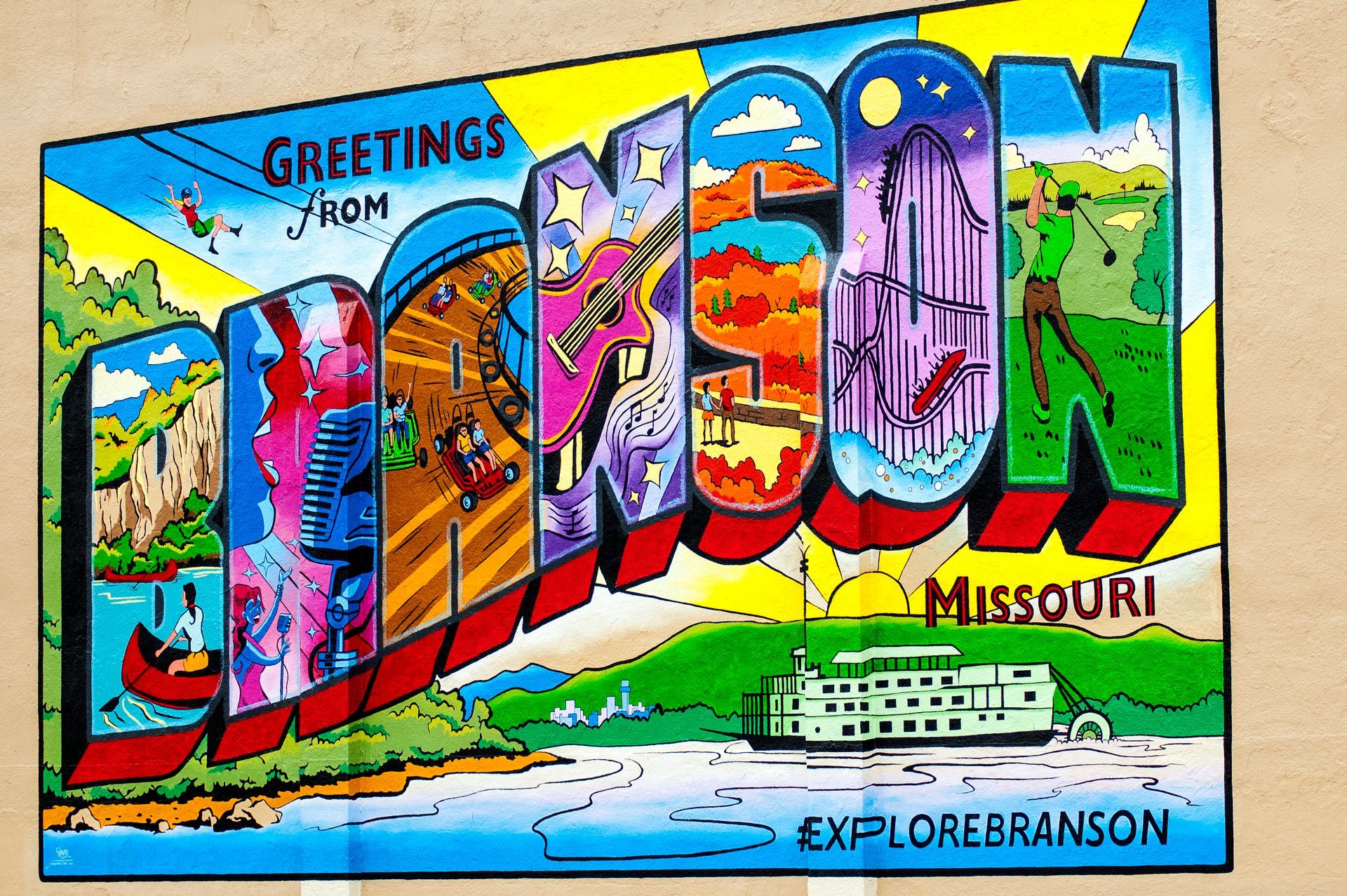 Colorful mural reading “Greetings from Joplin, Missouri” with local landmarks and scenic illustrations.