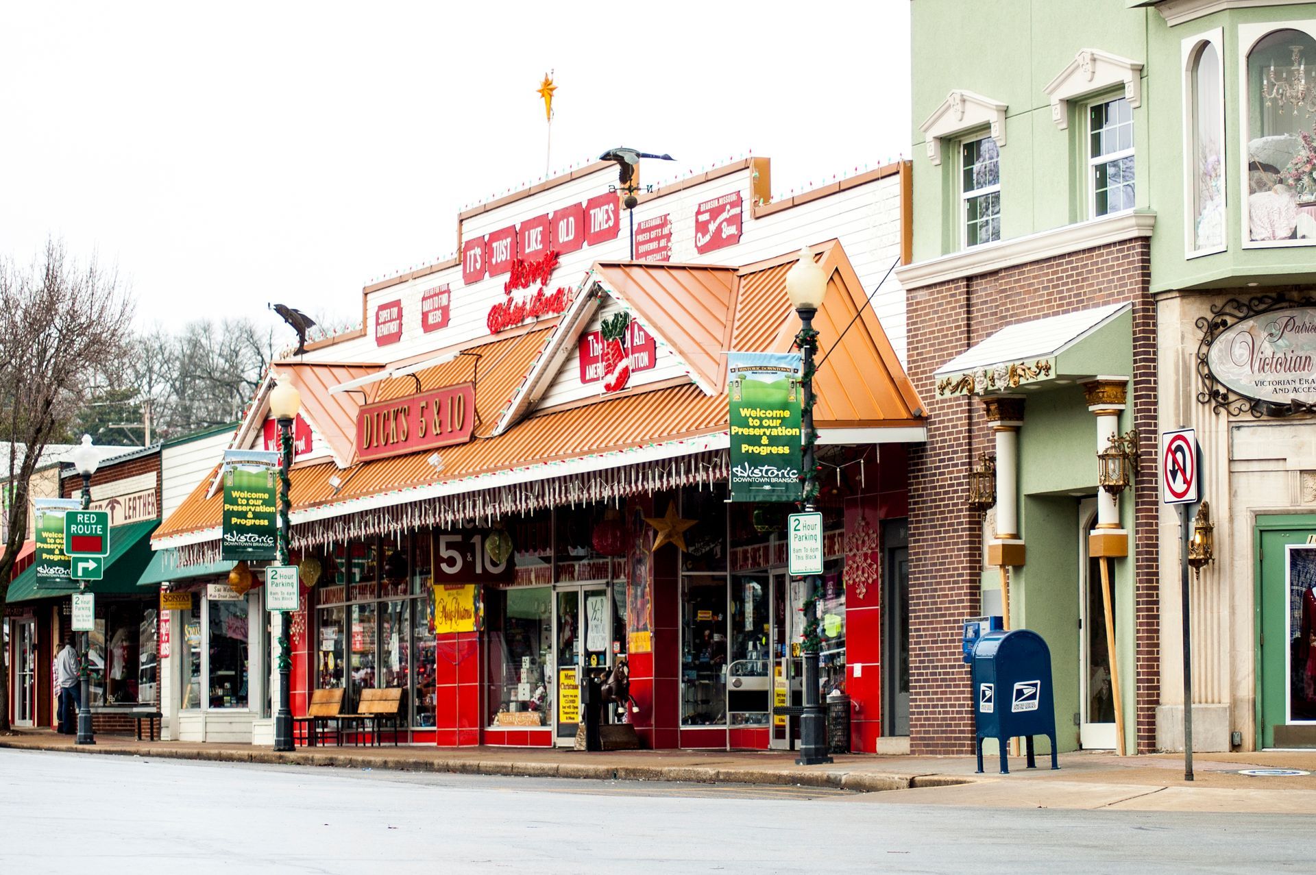 Colorful storefronts with orange awnings on a quiet street corner in a small-town shopping area