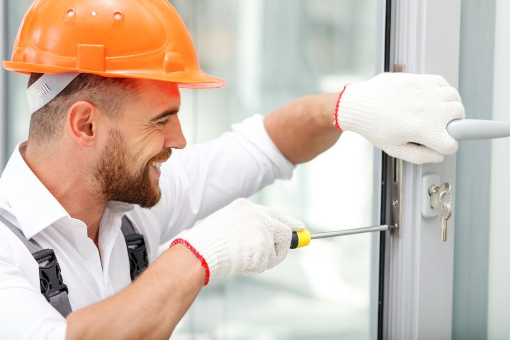 Attractive Young Builder Is Installing Lock In Door And Windows — Glass Repairs & Installations in Quirindi, NSW