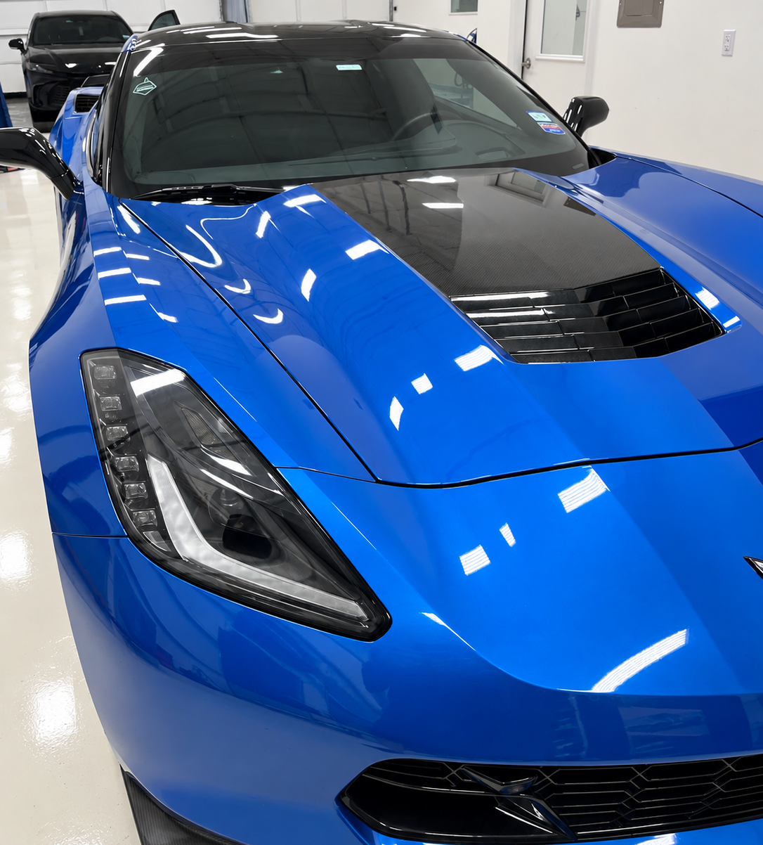 Front view of blue 2016 C7 Corvette showing the finished paint under shop lighting