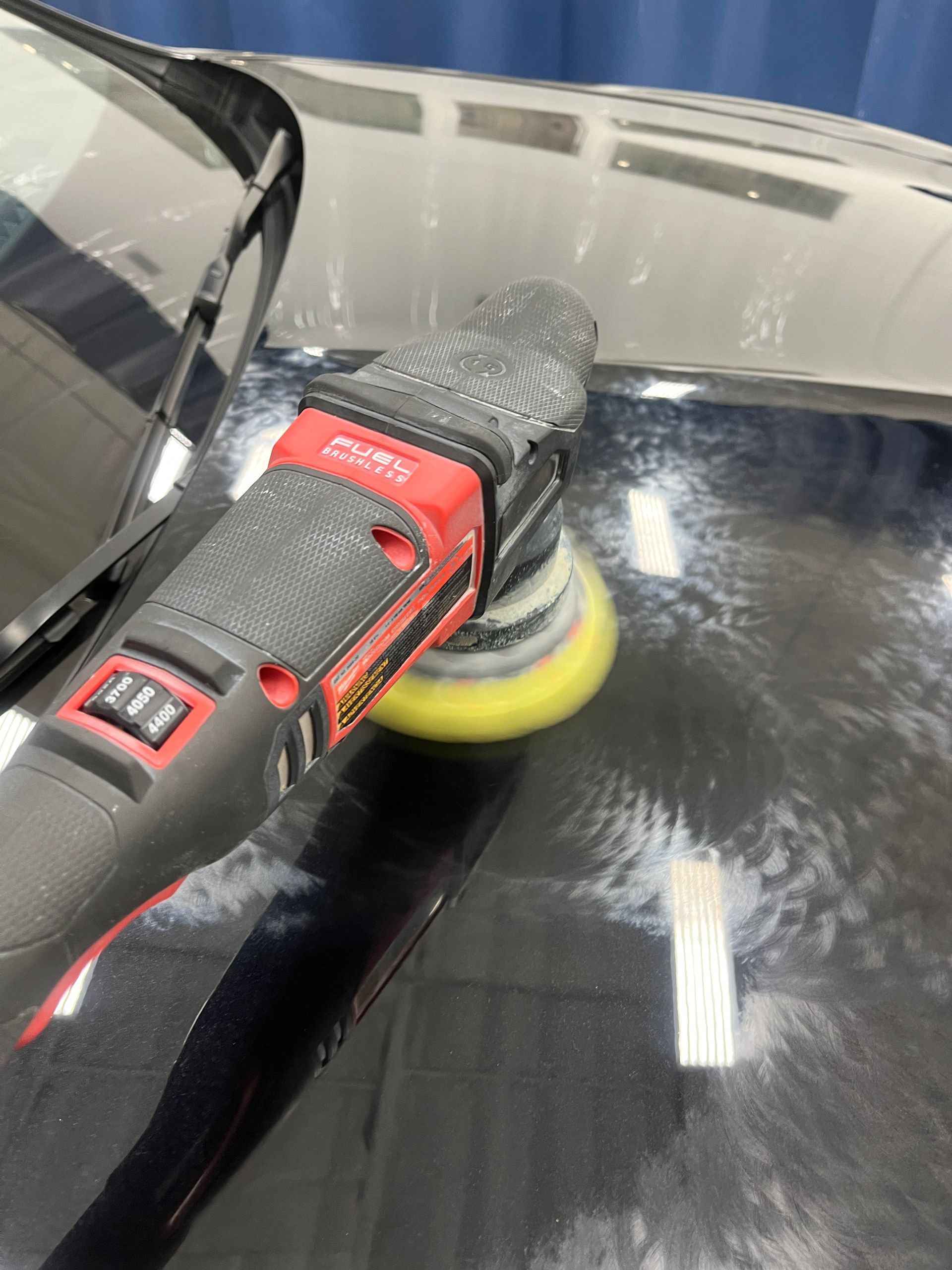 A dual action polisher and a foam pad polish the black hood of this 2025 Bentley Continental GT Black Edition to remove some minor swirl marks.