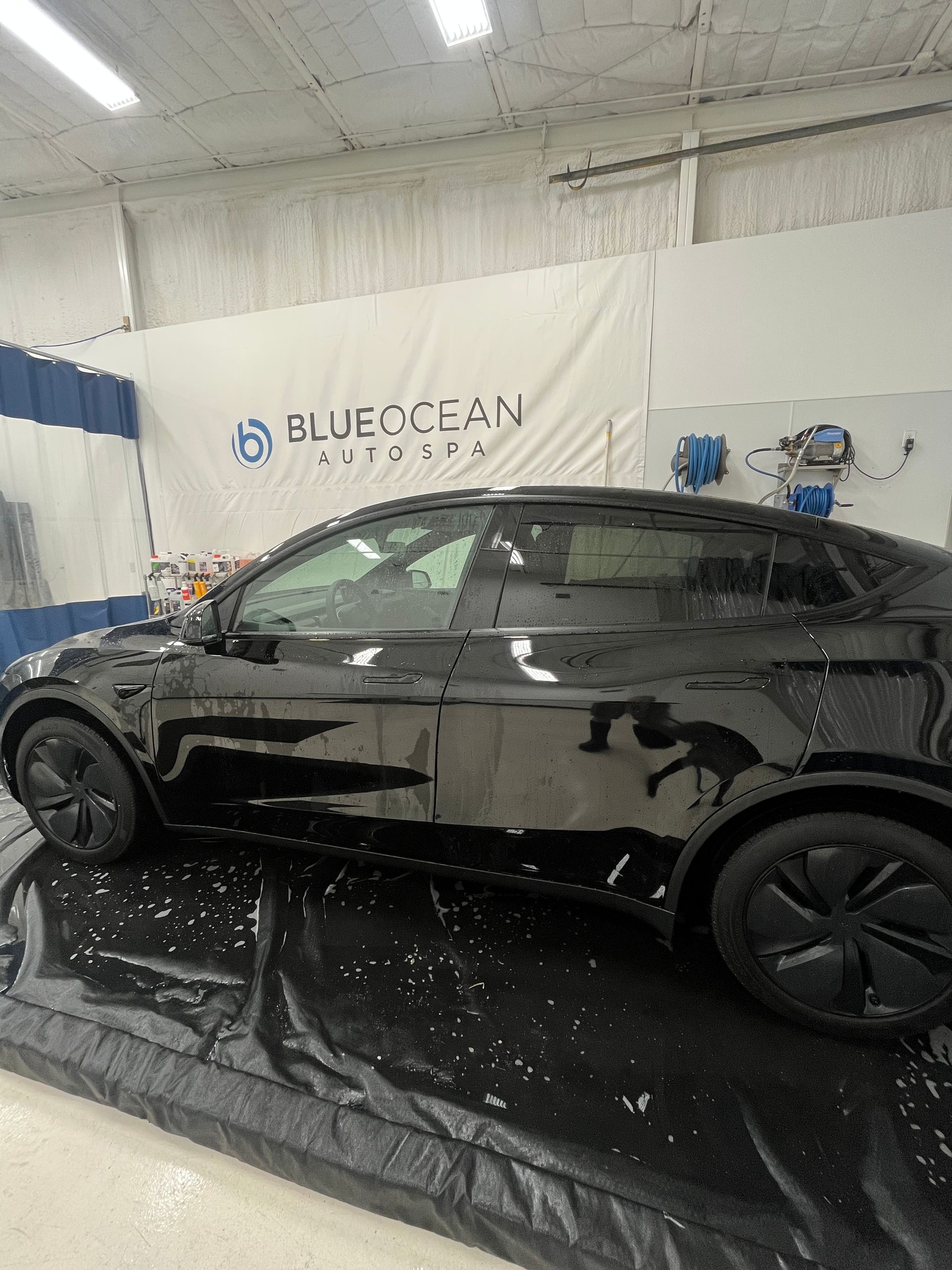 Tesla Model Y being washed in an indoor wash bay at Blue Ocean Auto Spa in Cedar Park, TX