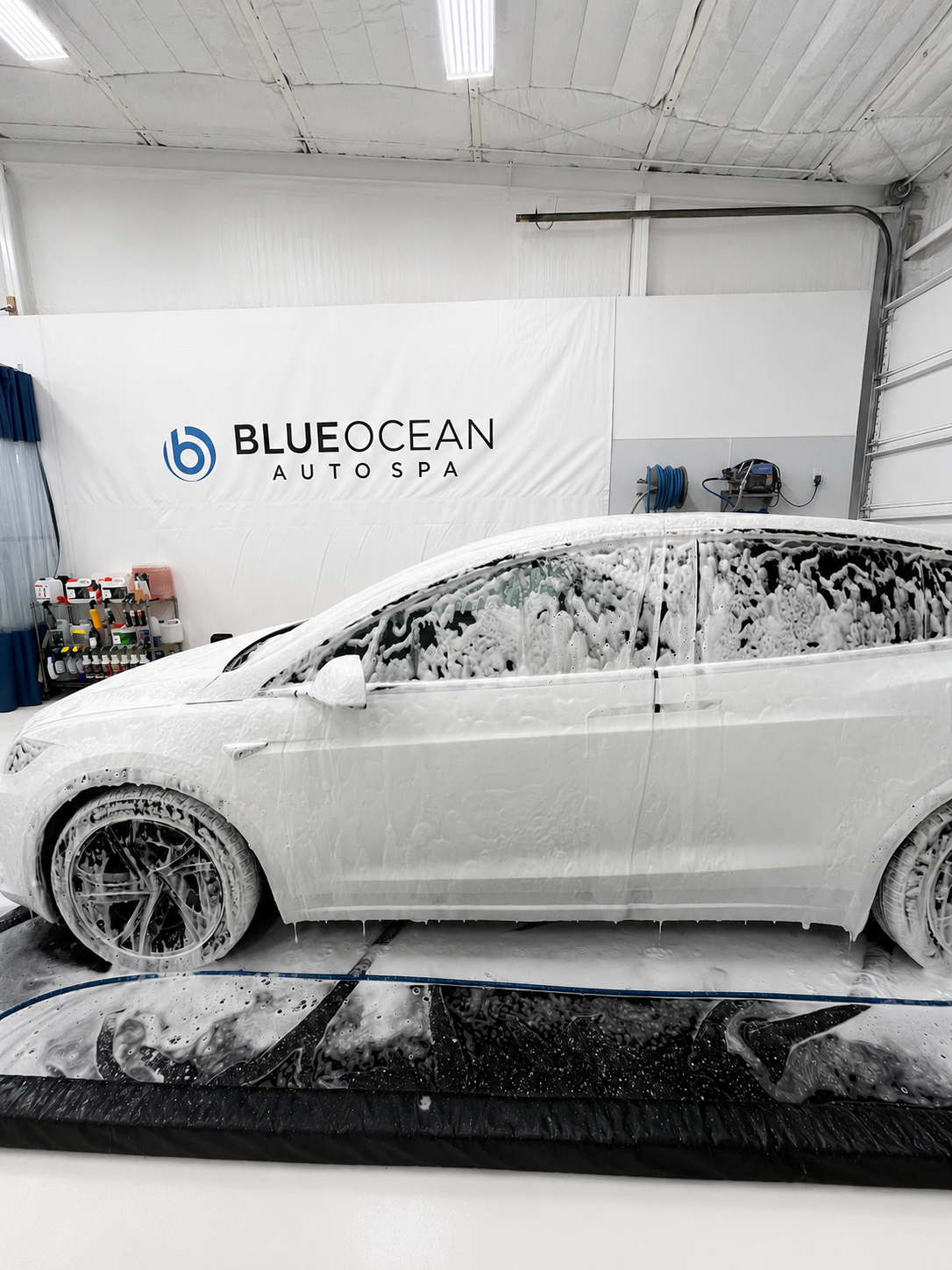 Washing a Tesla Model X with a ph balanced car wash soap in Blue Ocean Auto Spa indoor wash bay.  Washing a car out of the sun is the best way to wash.