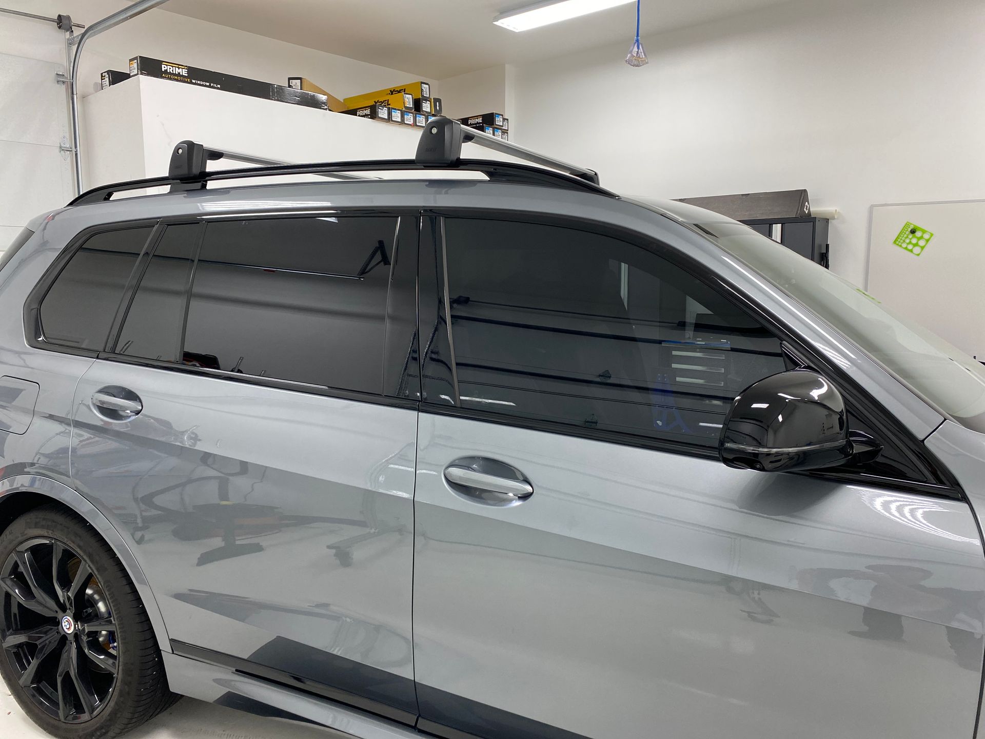 Silver SUV in a garage with roof rack and dark tinted windows