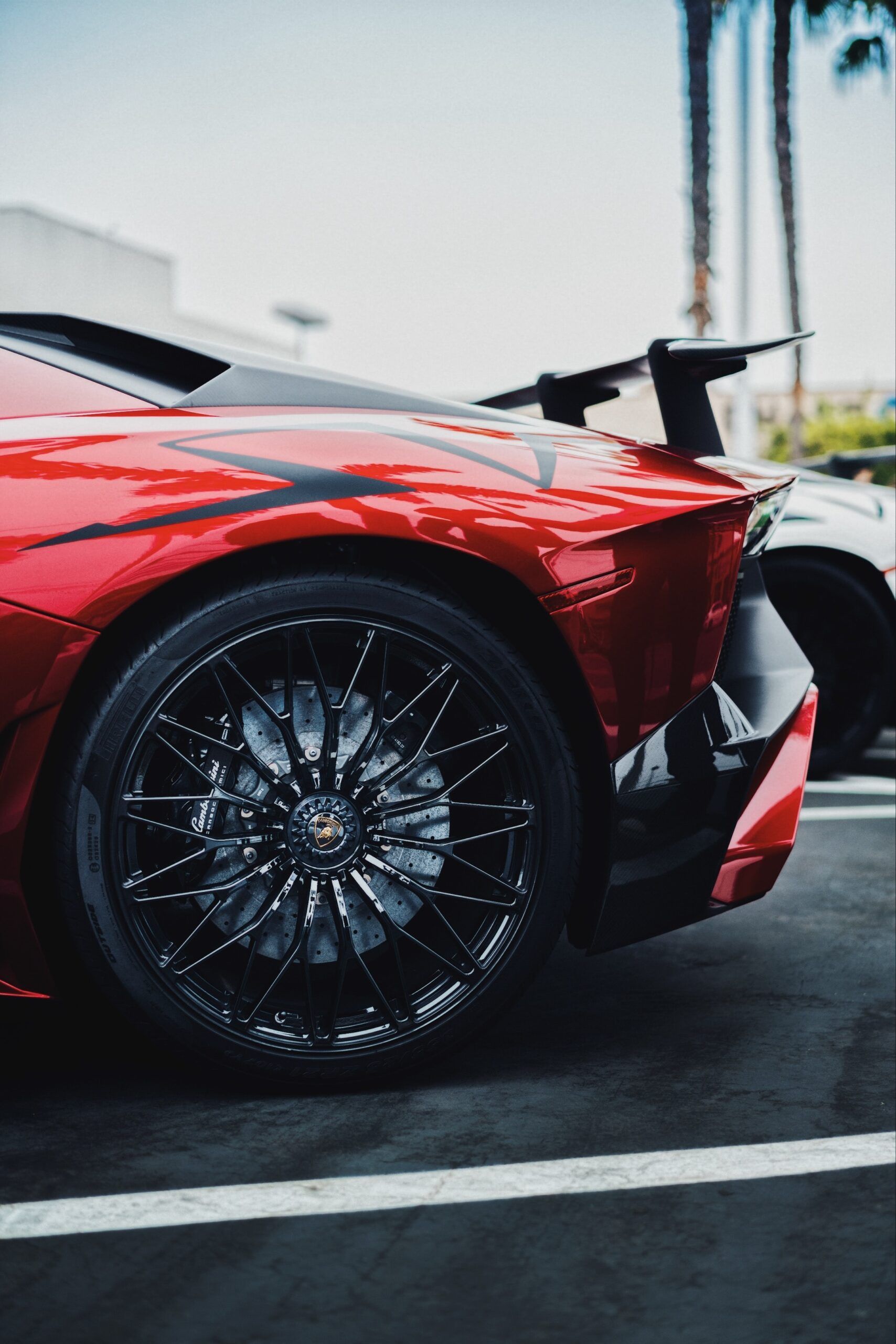 A close up of a red sports car parked in a parking lot.
