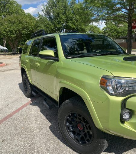 A green toyota 4runner is parked in a parking lot.