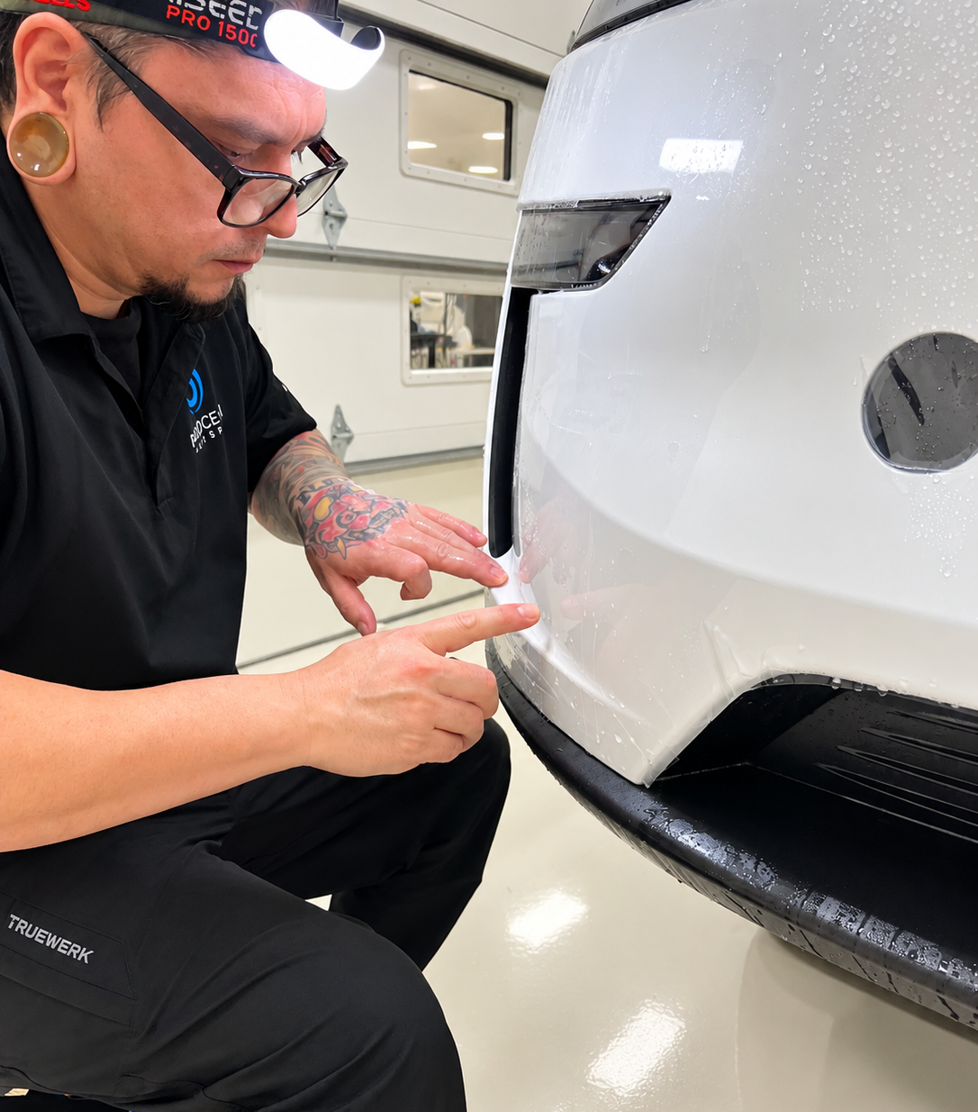 Blue Ocean installer fitting paint protection film on white Tesla Model Y L