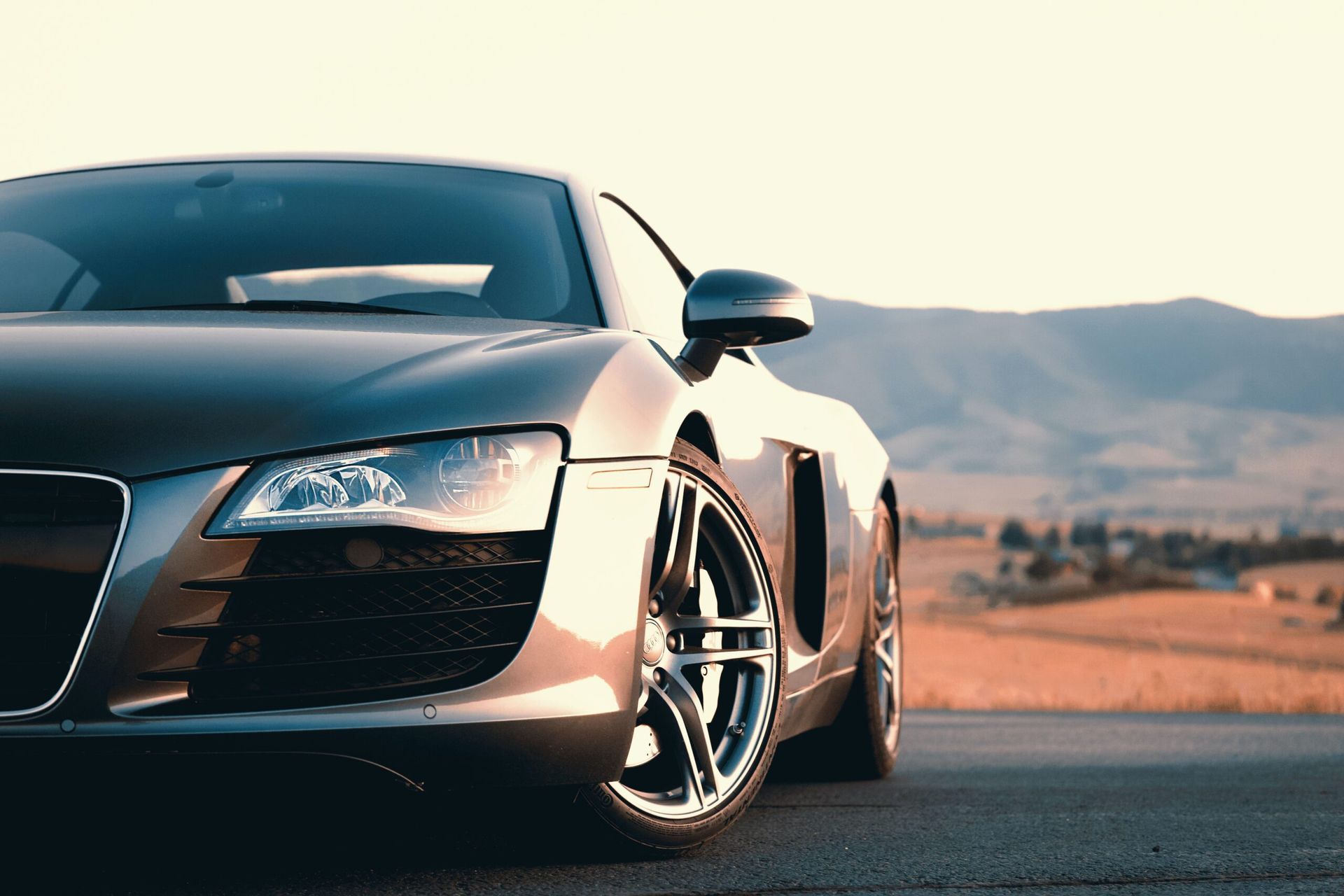 A close up of a sports car parked on the side of a road.