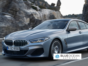 A silver bmw is parked on the side of the road