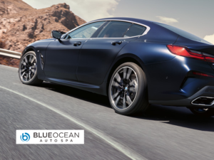 A blue ocean auto spa car is driving down a road