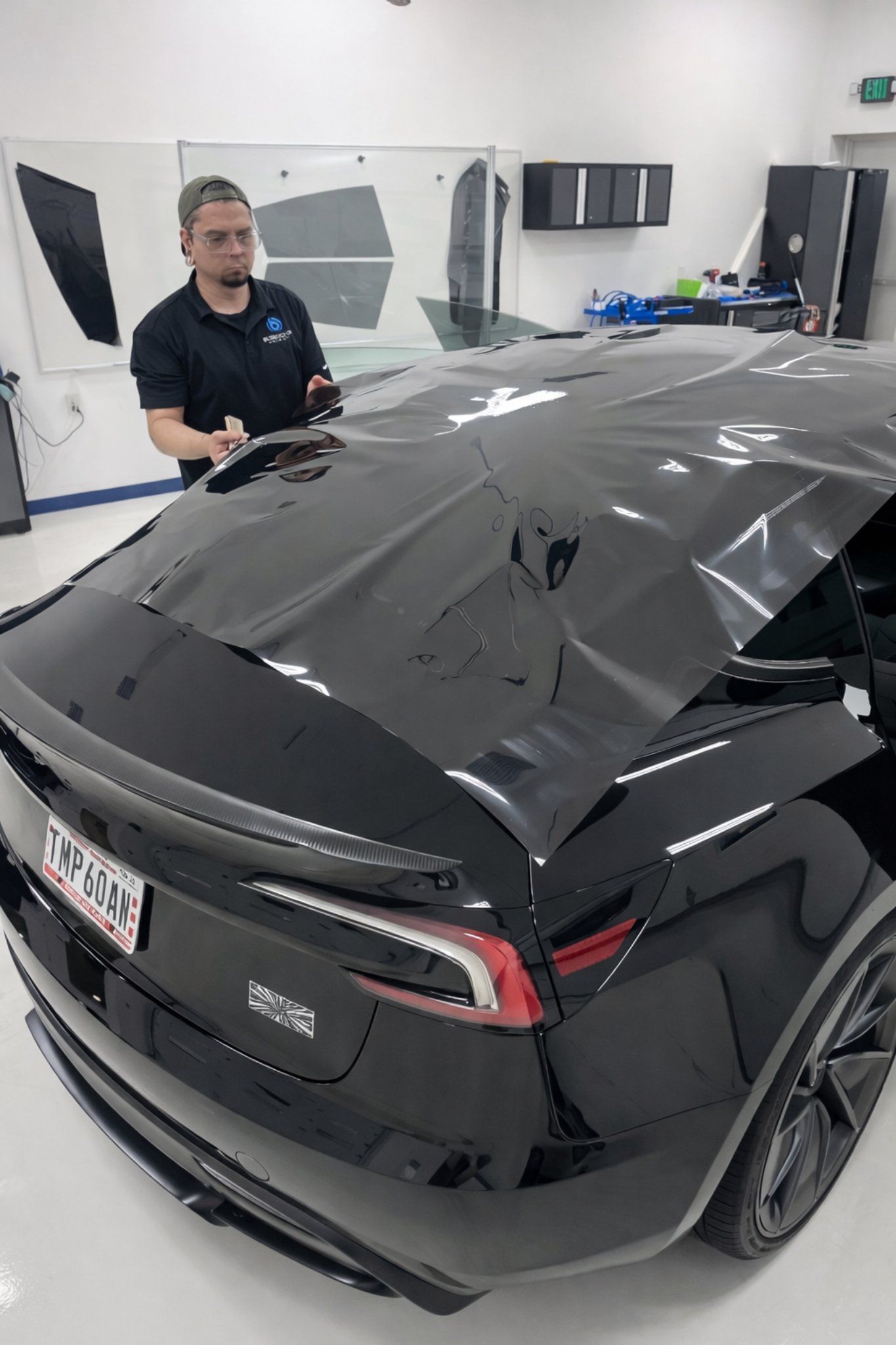 A Blue Ocean Auto Spa of Cedar Park technician prepares to heat shrink this extra large rectangle of ceramic tint on the outside of the glass so that the tint will conform to the contours of  the rear glass when it is installed on the interior side of the glass.