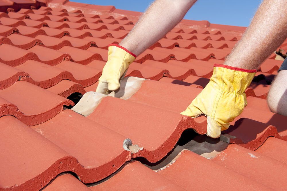 A Person Wearing Yellow Gloves is Working on a Roof — Mr. Roof Tiles in Ballina, NSW