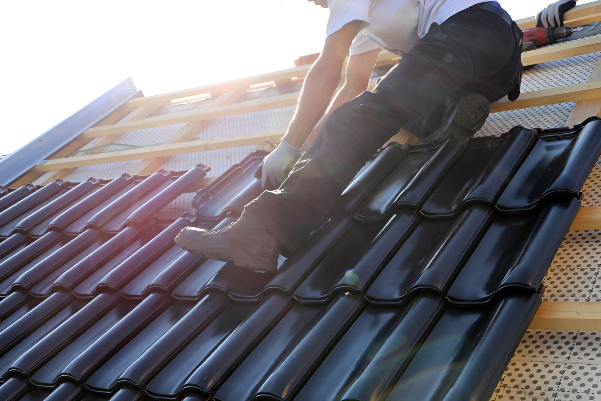 A Man is Laying Tiles on a Roof — Mr Roof Tiles in Kingscliff, NSW