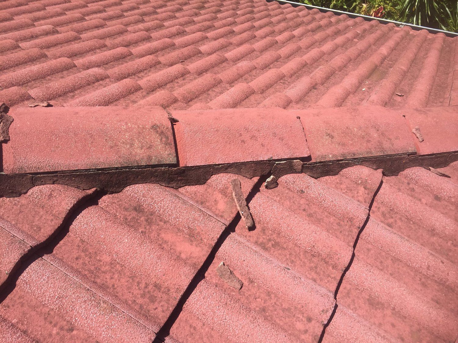 A Close Up of a Red Tiled Roof With a Gutter on It — Mr. Roof Tiles in Kingscliff, NSW