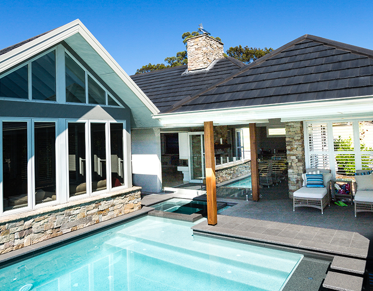 A Large House With a Swimming Pool in Front of It — Mr. Roof Tiles in Kingscliff, NSW