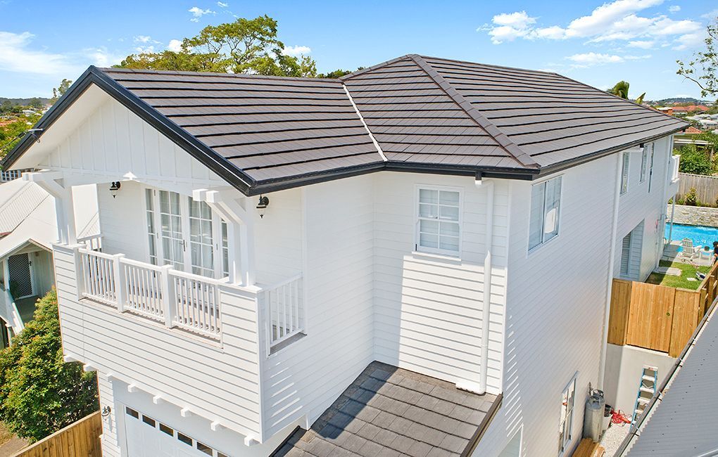 An Aerial View of a White House With a Black Roof — Mr Roof Tiles in Brisbane, QLD
