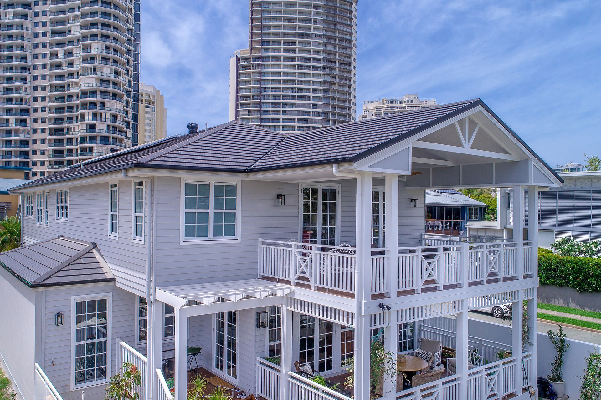 An Aerial View of a White House With a Black Roof and a Large Porch — Mr Roof Tiles in Grafton, NSW
