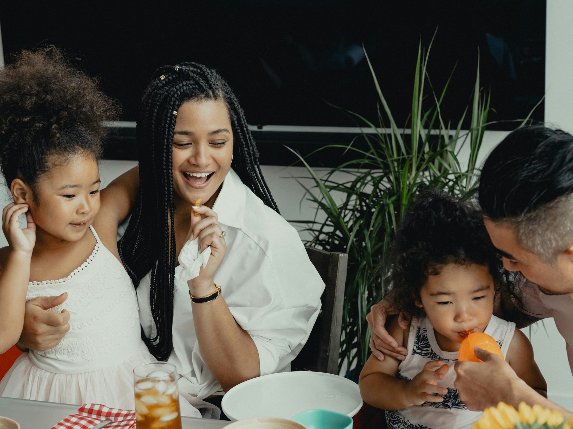 A family is sitting at a table eating food.