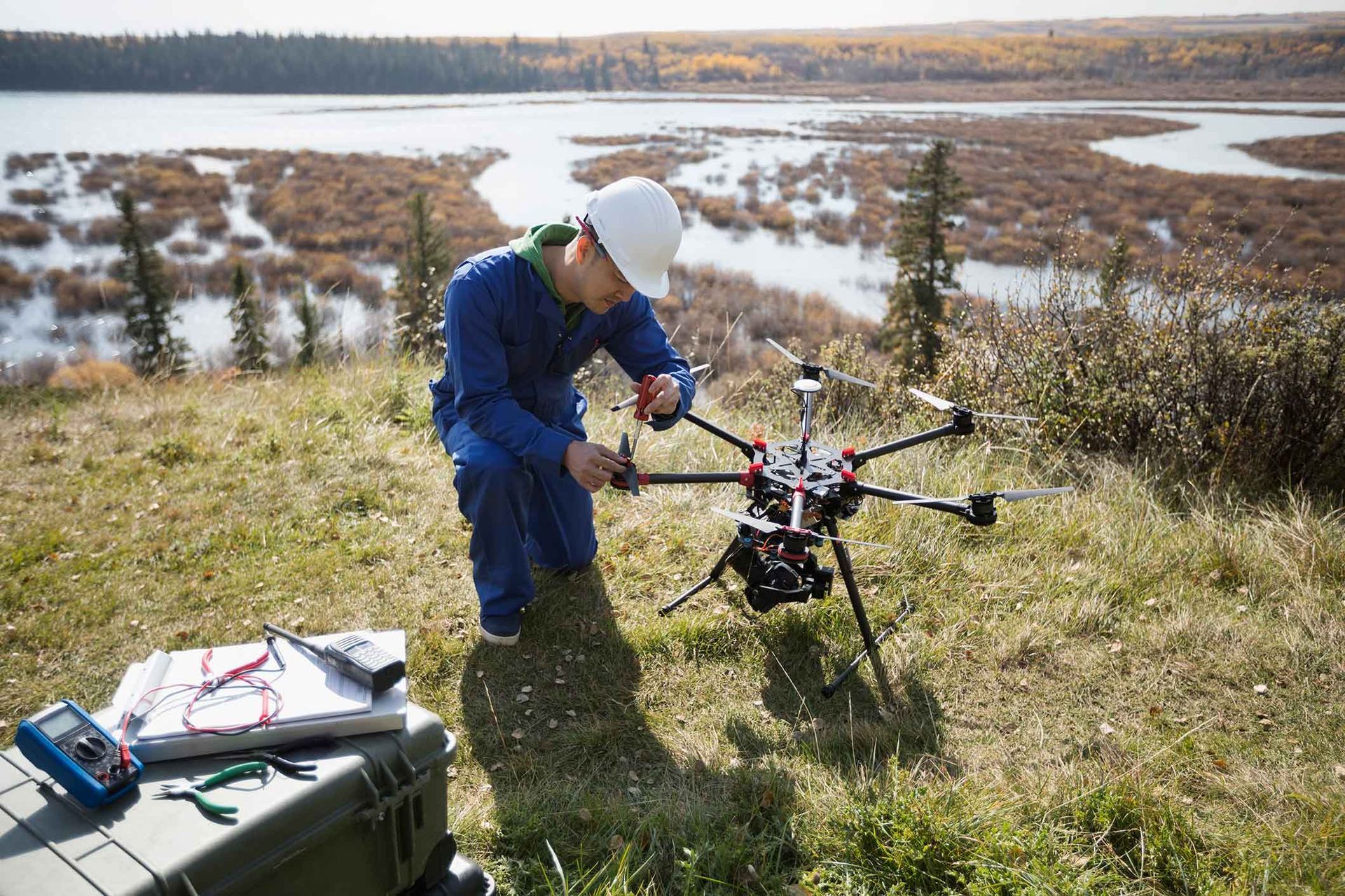 A Man Is Working On A Drone In The Grass Near A Lake – Warrnambool, VIC - Joseph Land Surveying