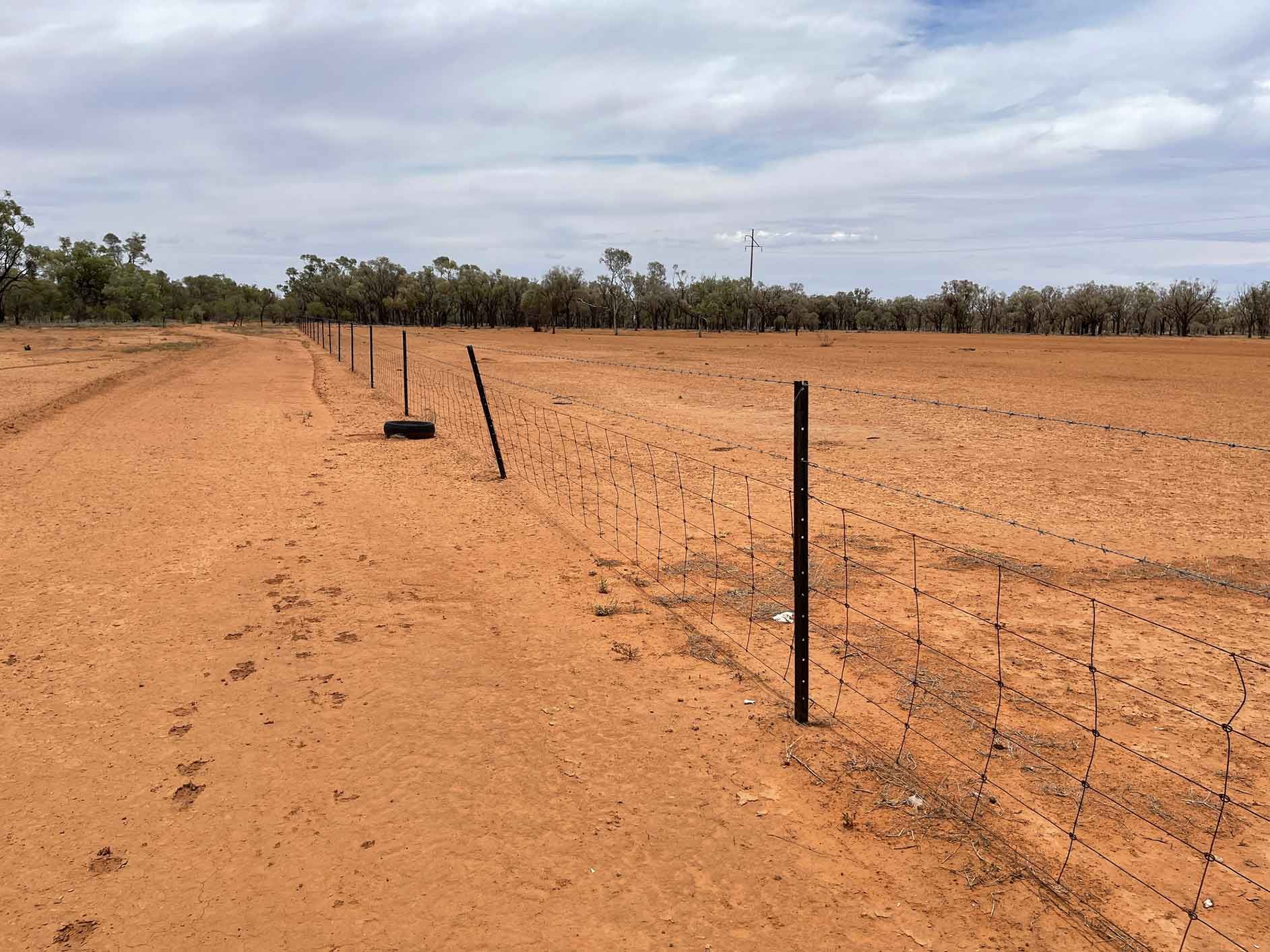 A Fence In The Middle Of A Dirt Field With Trees In The Background – Warrnambool, VIC - Joseph Land Surveying