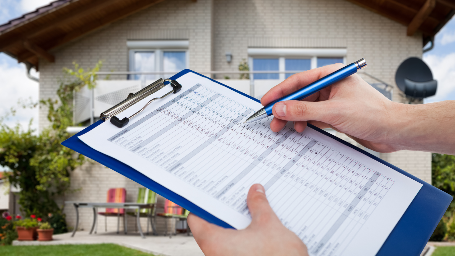 A person is writing on a clipboard in front of a house.
