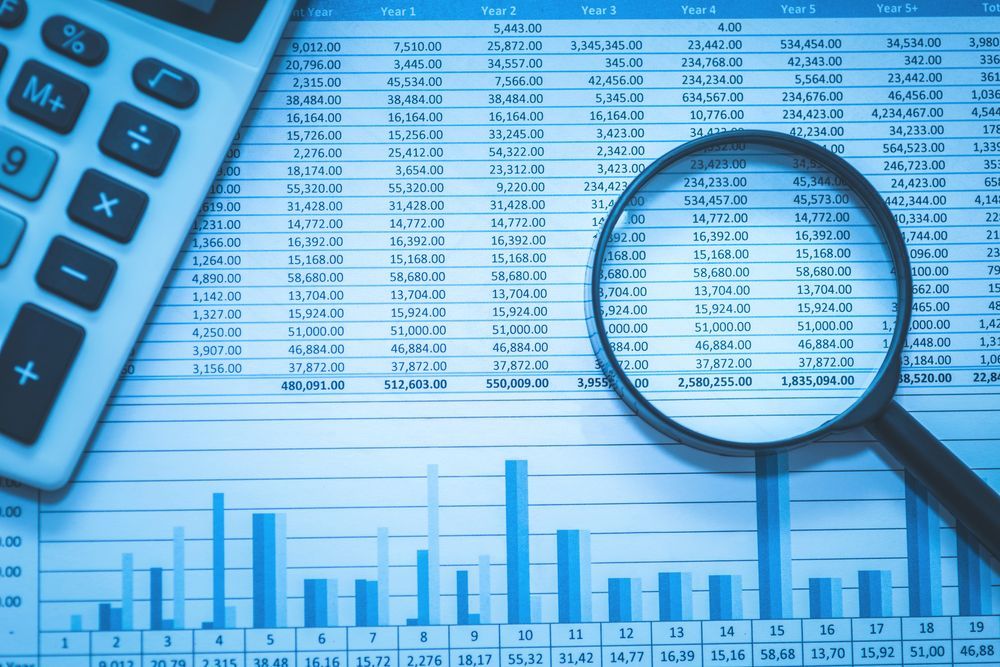finance sheet with magnifying glass — Tax Accountant in Rockhampton