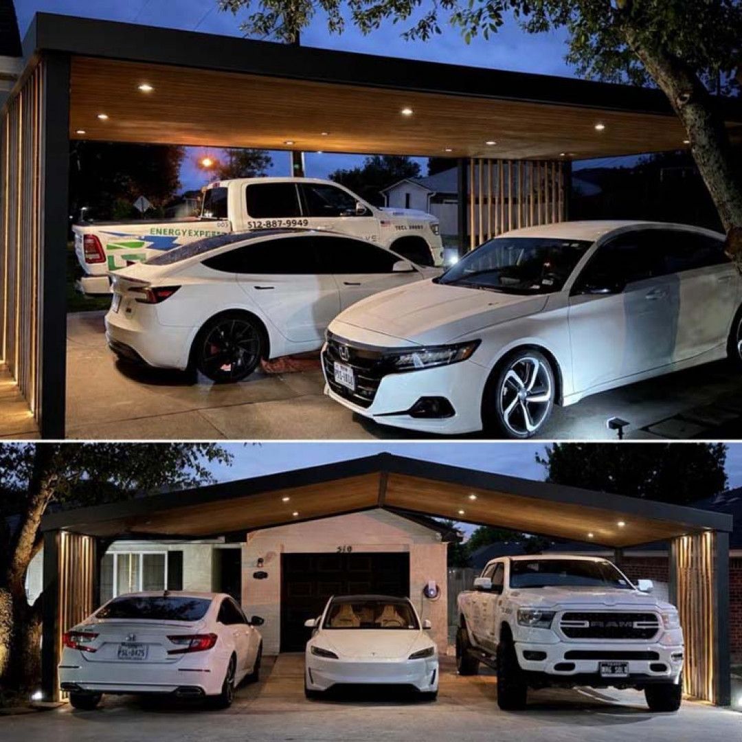 Three white cars parked in a lit driveway under a modern carport at night