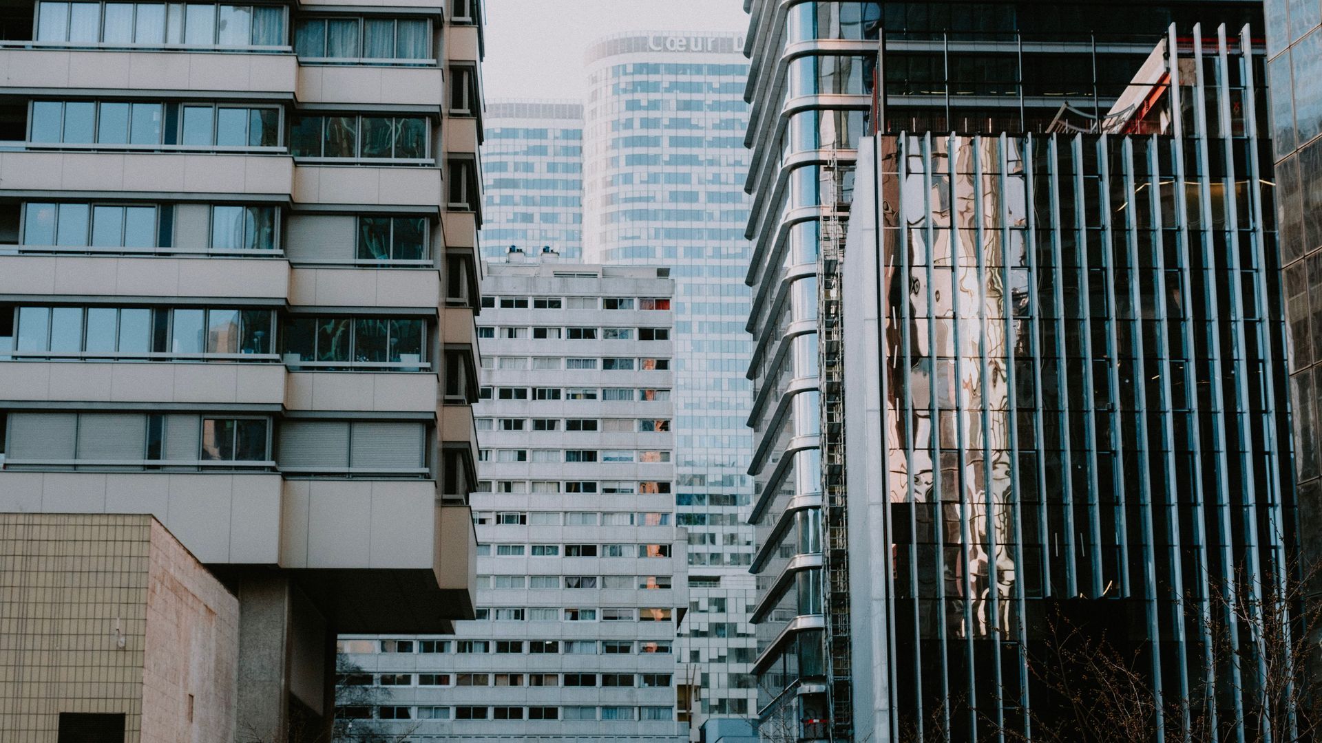 Urban street canyon with high-rise buildings and a construction crane in the center