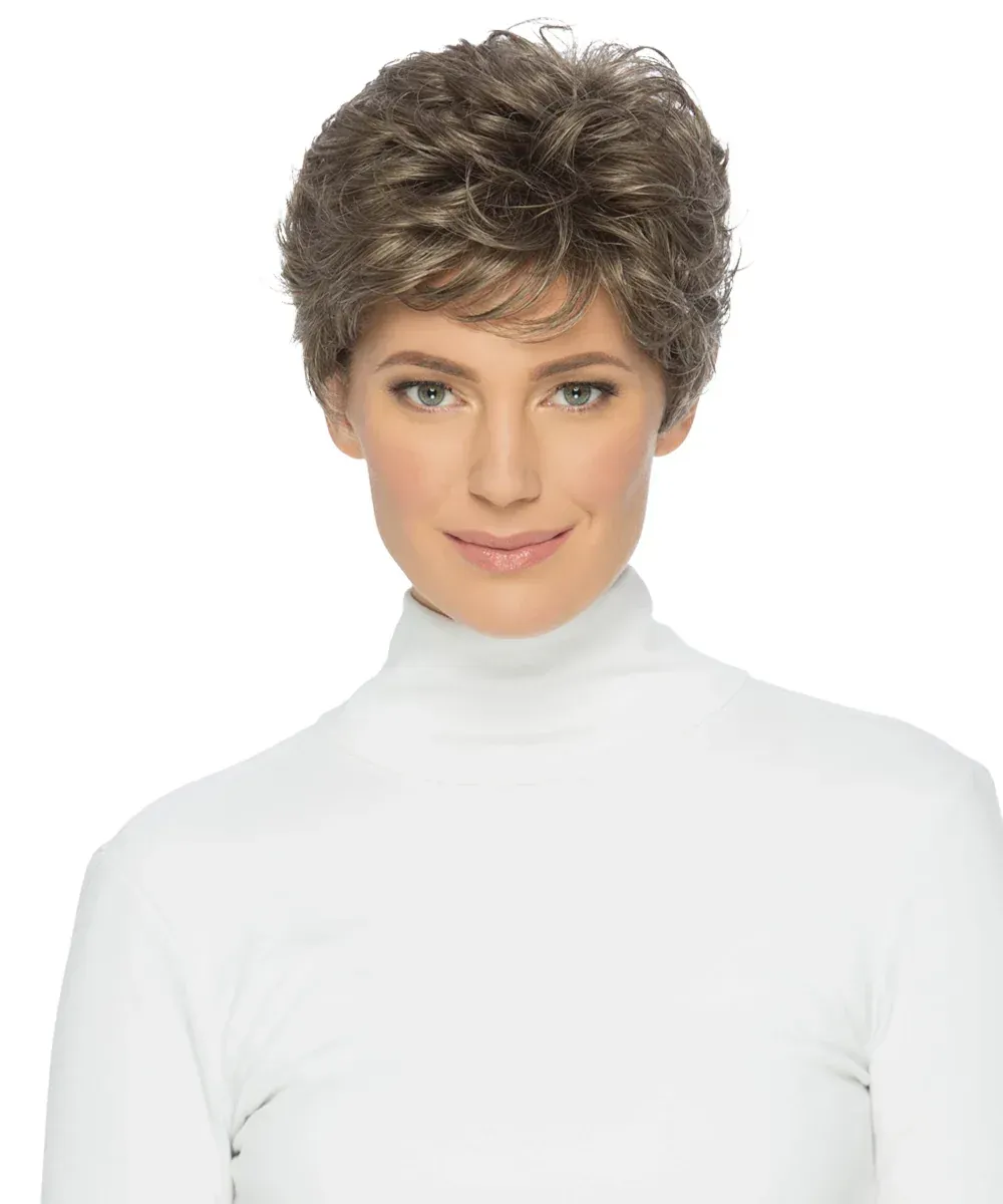 Woman with short, layered, gray wig, smiling, wearing a white turtleneck.