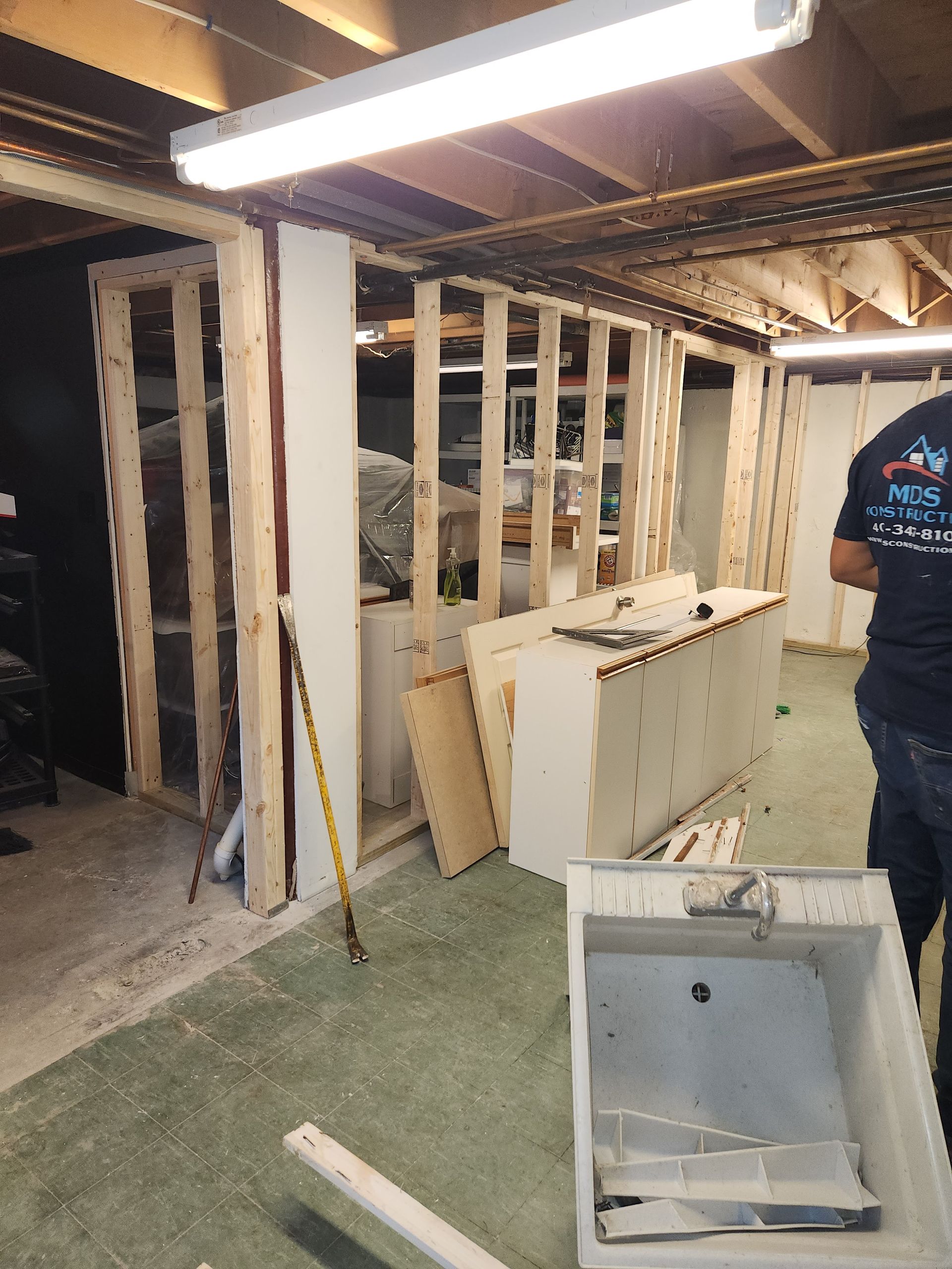 A man is standing in a room that is being remodeled.