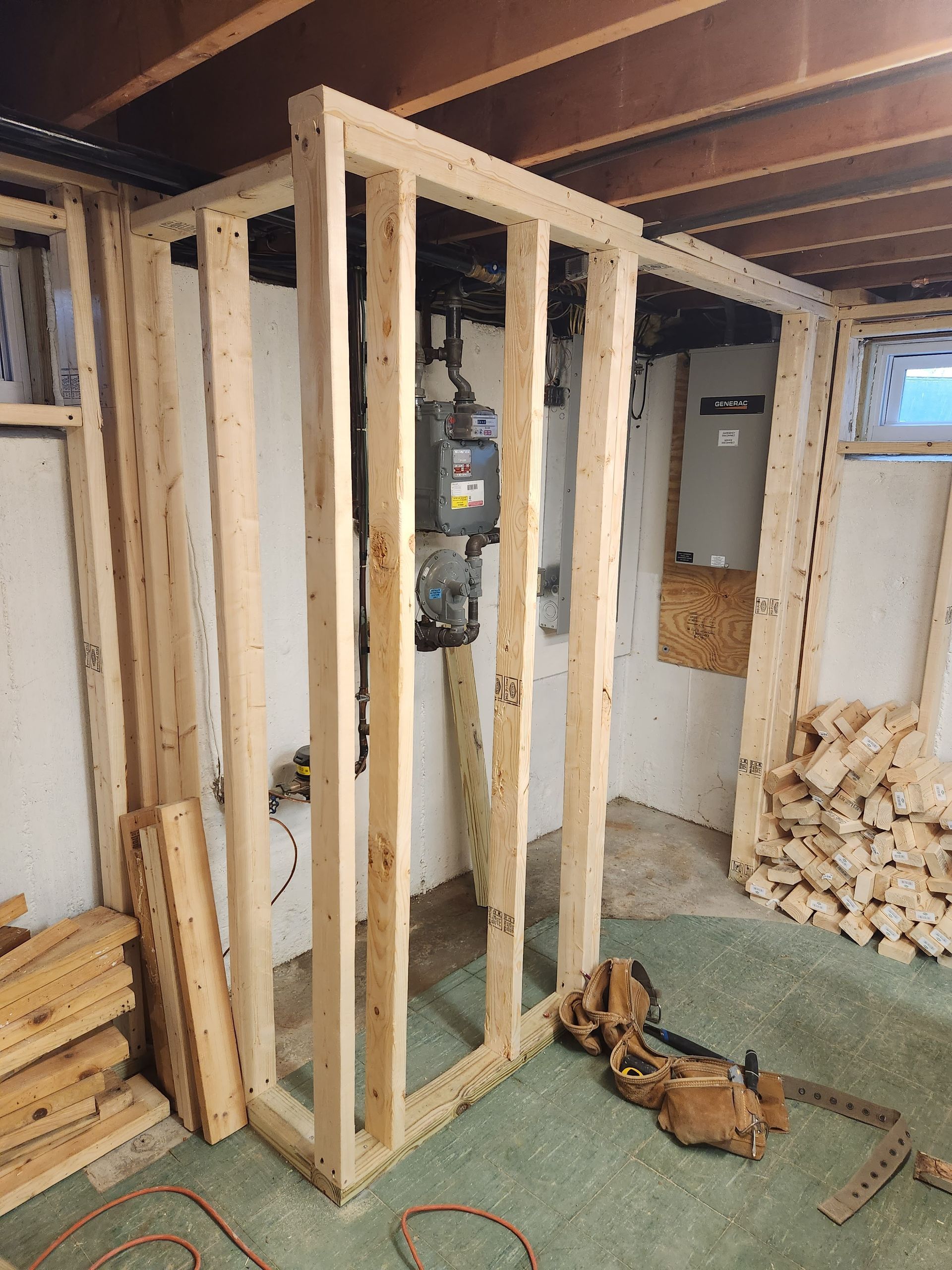 A wooden frame is being built in a basement.