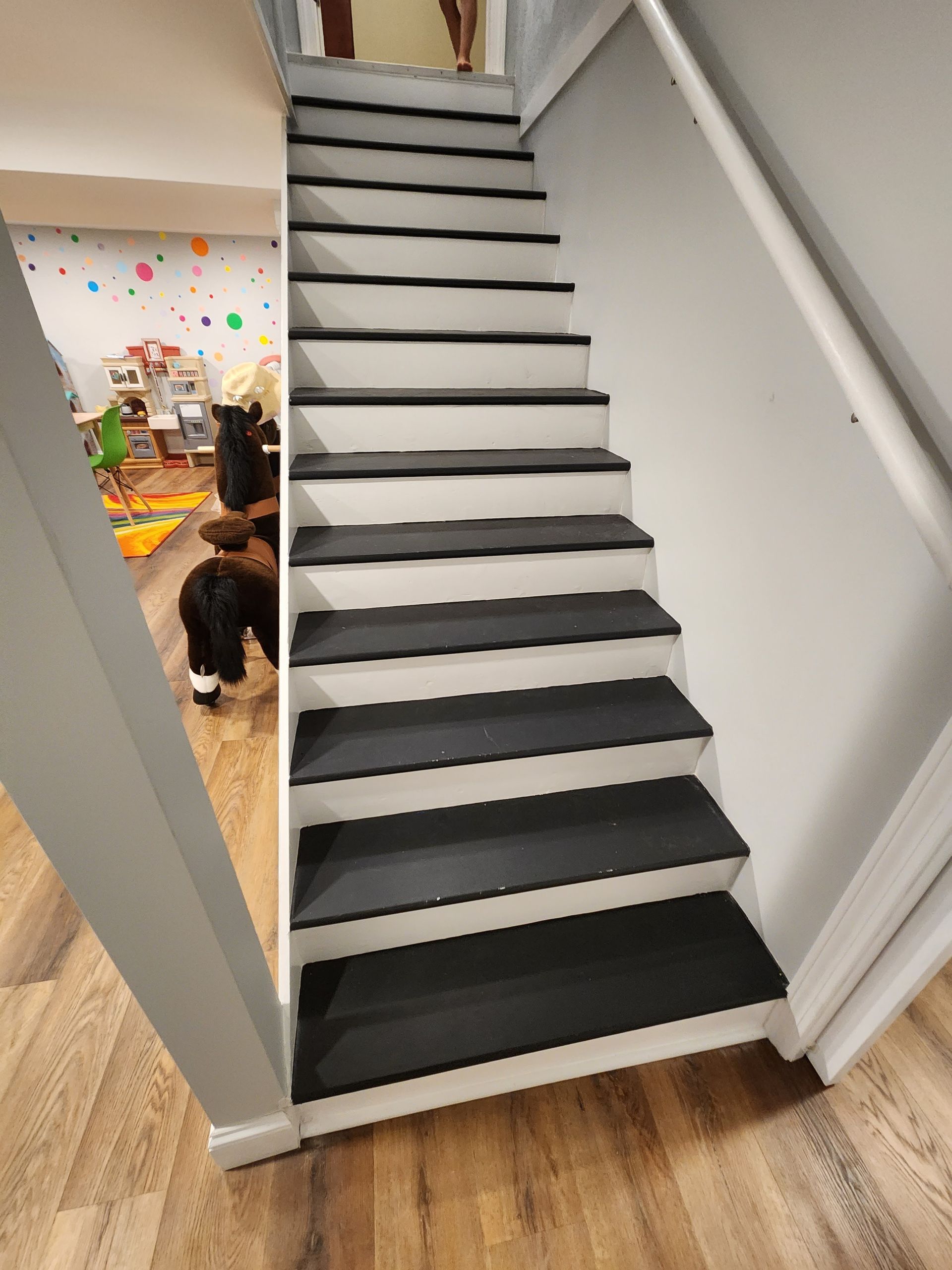 A black and white staircase with a wooden floor