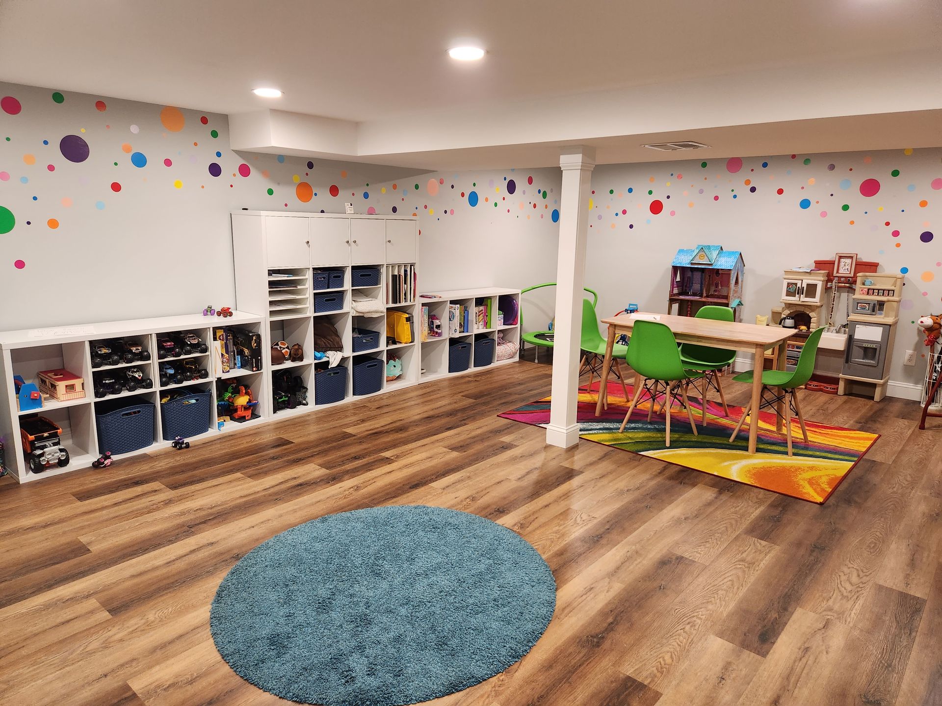 A basement with a table , chairs , shelves and a rug.