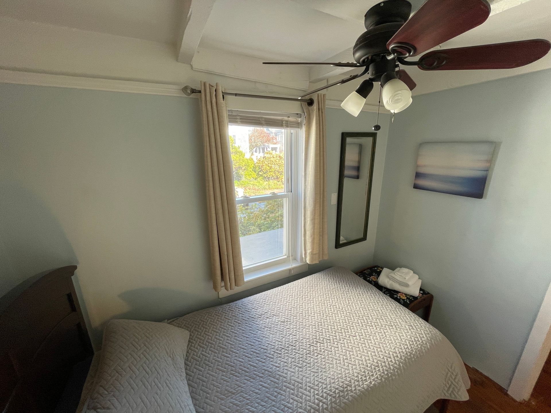 A bedroom with a bed and a ceiling fan