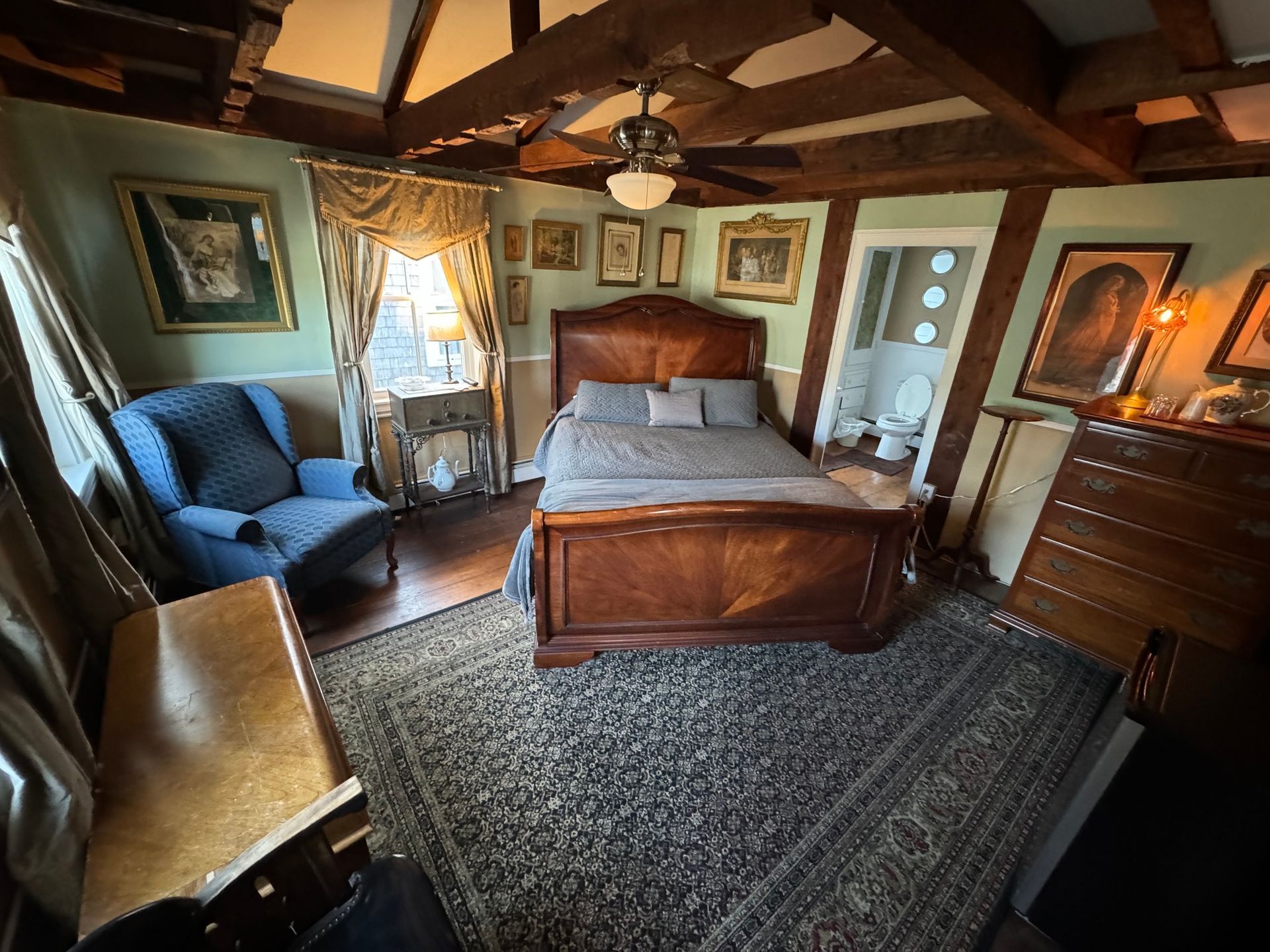 A bedroom with a bed , chair and dresser