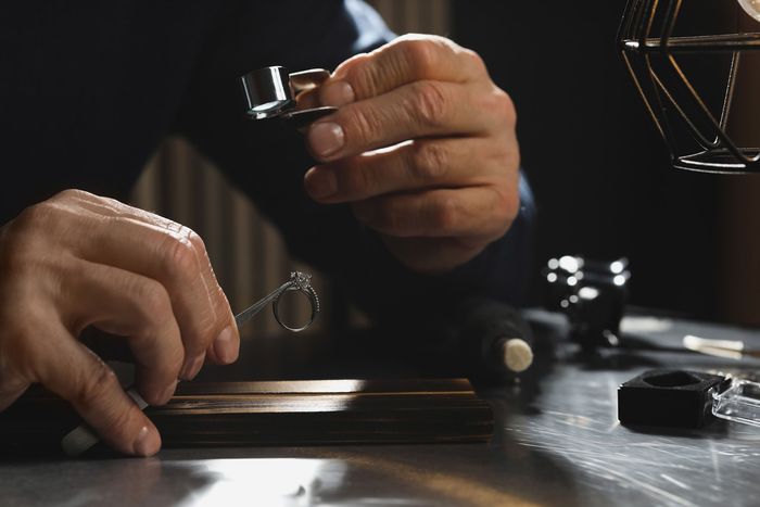 Professional jeweler working with ring at table — Champaign, IL — Leonard's Pawn & Jewelry Professional jeweler working with ring at table — Champaign, IL — Leonard's Pawn & Jewelry