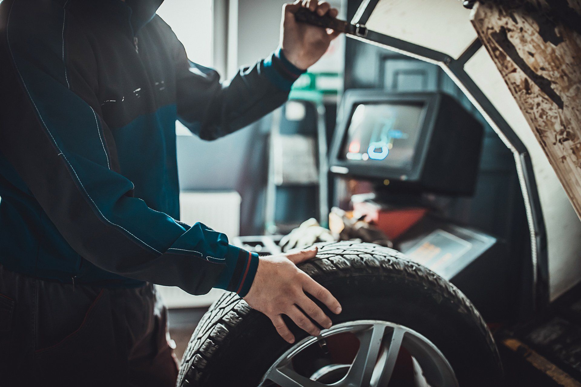 Auto Mechanic Working with Car Tire — New Haven, IN — Barker’s Automotive
