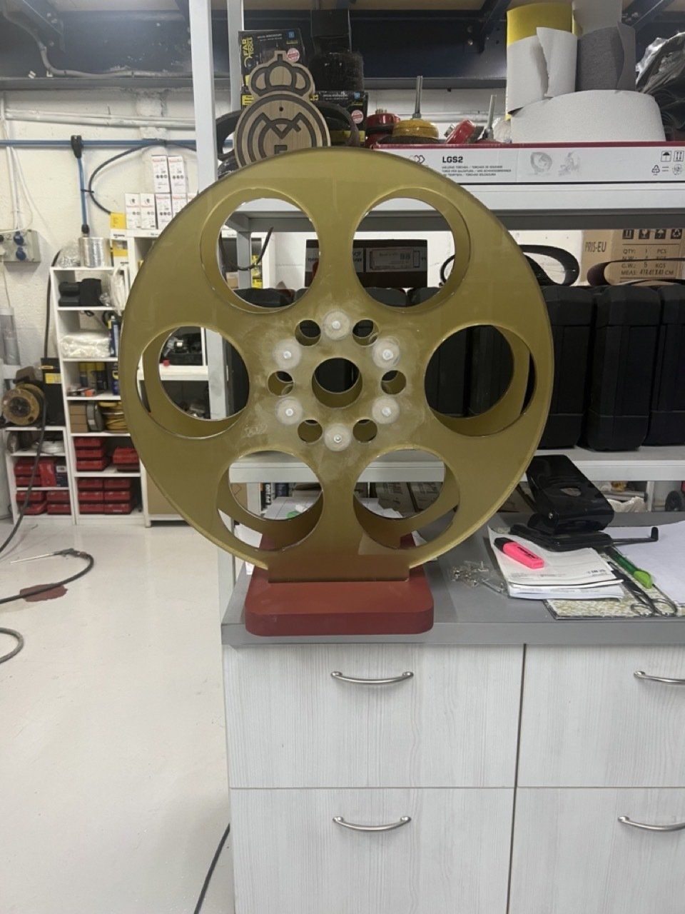 Un gran rollo de película de oro reposa sobre una mesa de madera.