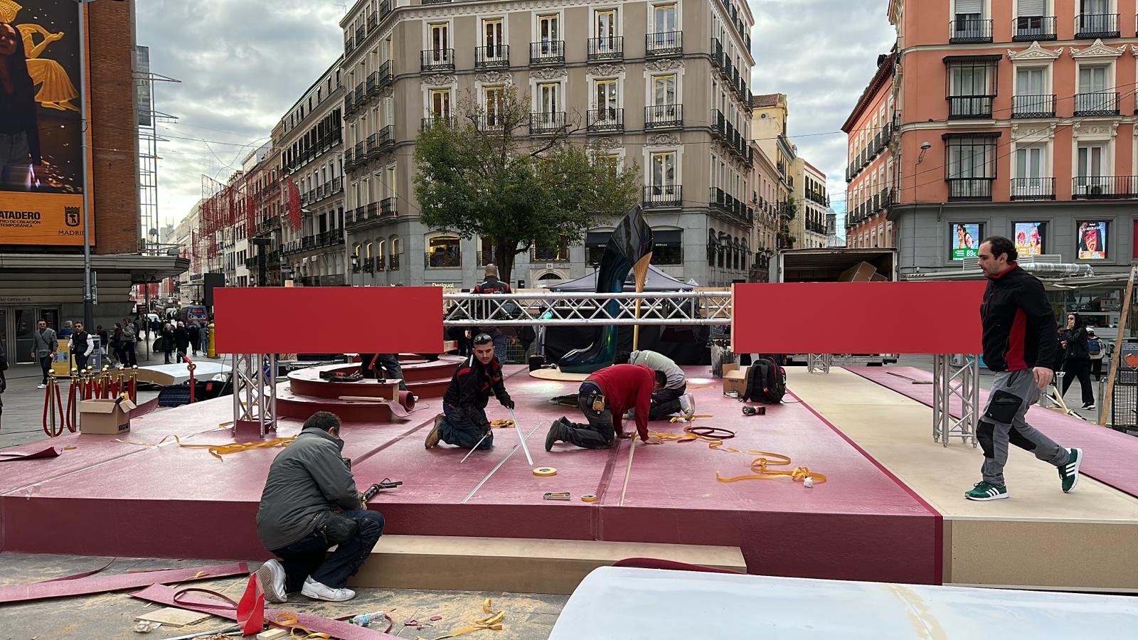 Un grupo de personas está trabajando en un escenario en una ciudad.