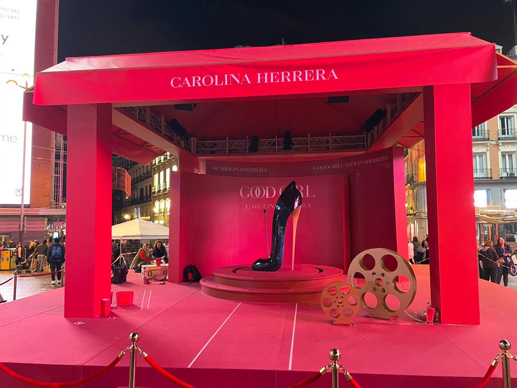 Un escenario rosa con un cartel de Carolina Herrera.
