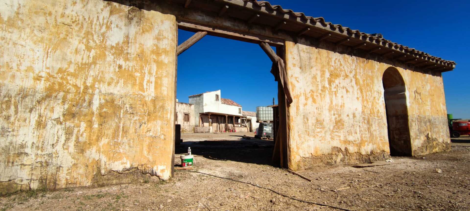 Un edificio antiguo con un arco de madera que conduce a una casa.