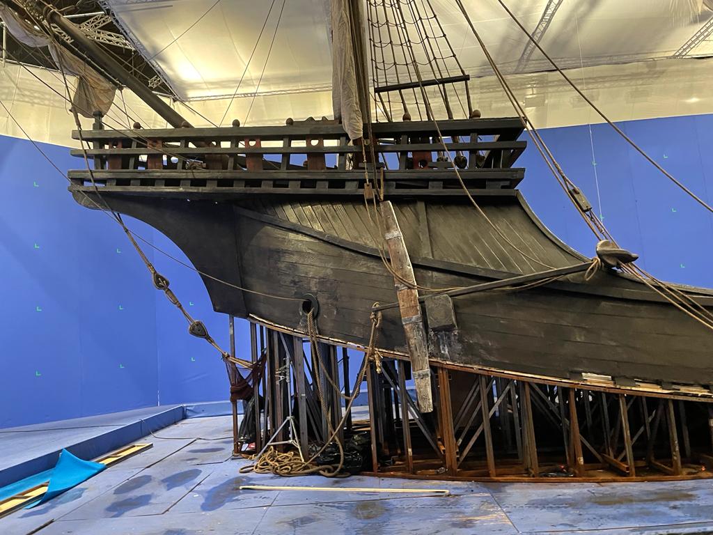 En una sala con fondo azul se exhibe una maqueta de un barco.