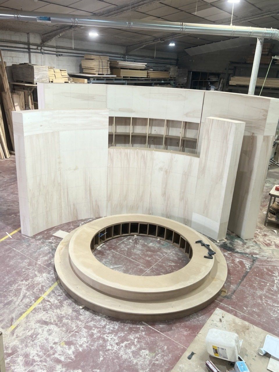 Un gran círculo de madera está sentado encima de una mesa de madera en un almacén.