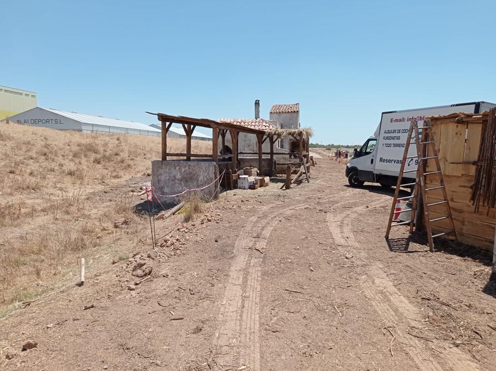 Una camioneta blanca está estacionada en medio de un camino de tierra.