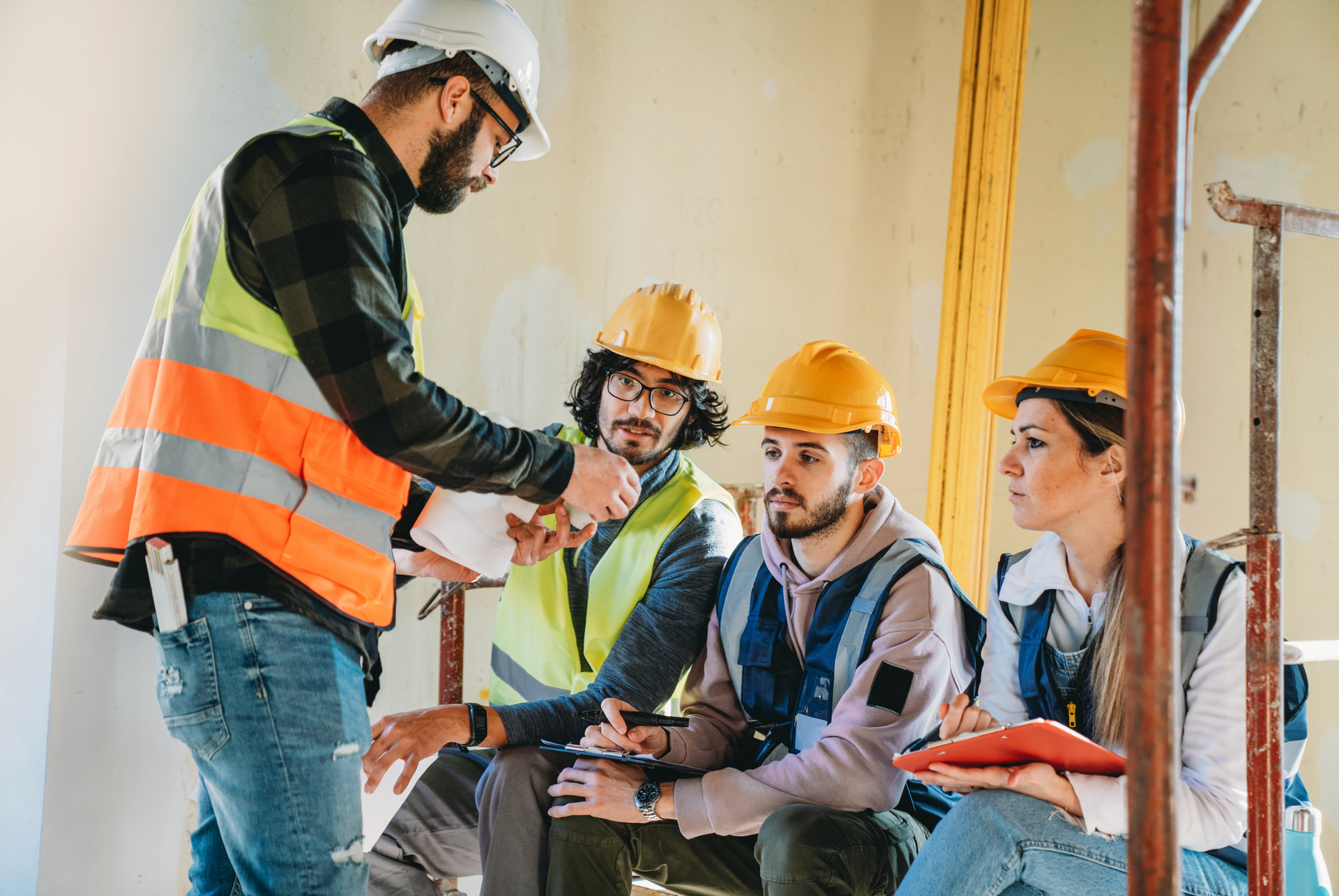 A group of construction workers are having a meeting on a construction site.