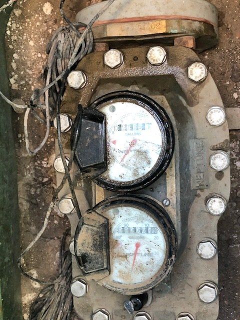A close up of a water meter with two gauges on it.