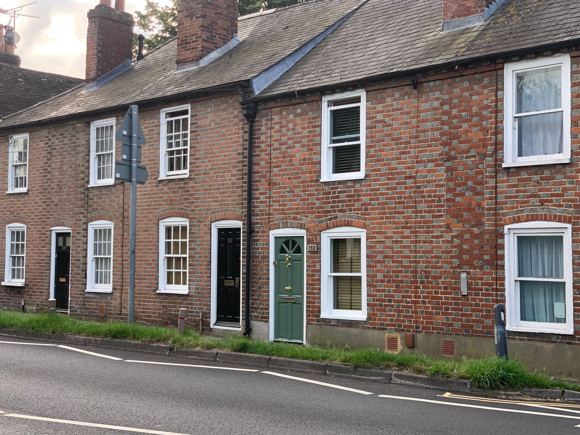 Properties with Party Walls Row of brick terraced houses with white-trimmed windows and colourful front doors along a street