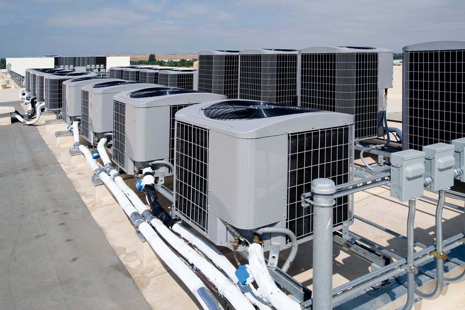 A row of air conditioners on top of a building