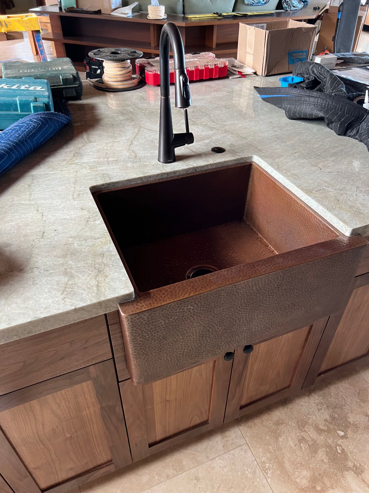 Plumber with toolbox by a kitchen sink.