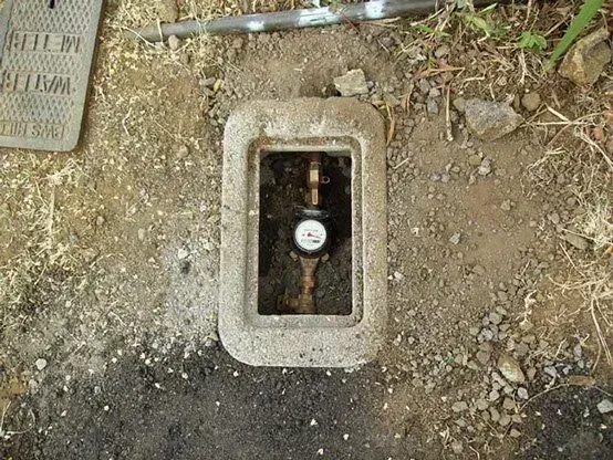 Water meter inside a concrete box in the ground.